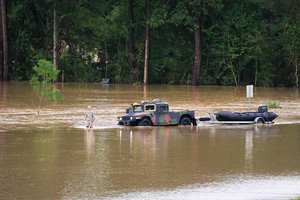 File - A soldier guides a Humvee towing a rescue boat through high waters during the search for flood victims in Denham Springs, Livingston Parish, Louisiana, Aug. 14, 2016.