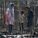 Migrants amid the remains of a tent on Tuesday after a fire at the Moria migrant camp on the Greek island of Lesbos.