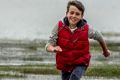 Tom Osborne, 11, splashes through the shallows of Lake George. 