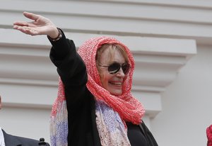 U.S. actress Mia Farrow waves from the balcony of the Ecuadorian presidential palace, during the weekly changing of the guard ceremony in Quito, Ecuador