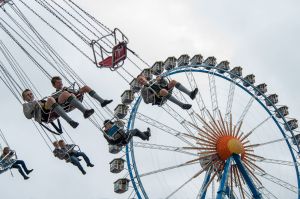 MUNICH, GERMANY - SEPTEMBER 18: Visitors in traditional Bavarian clothes take a ride on a funfair ride during day 2 of ...