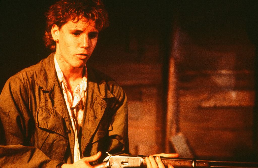 CIRCA 1988: Corey Haim holds a rifle as he is covered in blood in a scene from the Universal Studio movie  'Watchers' circa 1