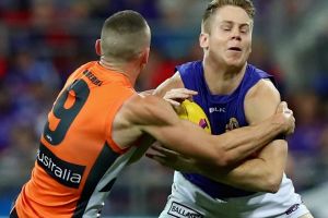 Giving it everything: Lachie Hunter of the Bulldogs is tackled by Tom Scully of the Giants.