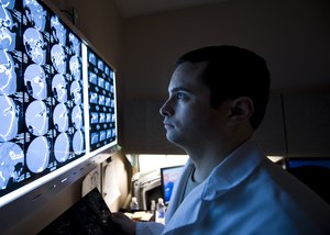 File - Capt. (Dr.) Wesley Reynolds studies a patient’s computed brain tomography scan at the Mike O’Callaghan Federal Medical Center March 18, 2014, at Nellis Air Force Base, Nev. March is brain injury awareness month.