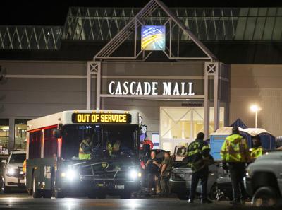 Emergency personnel stand in front of an entrance to the Cascade Mall. (AP photo)