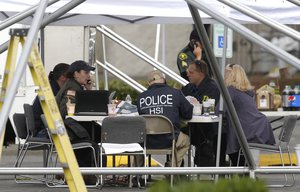 Law enforcement officials work under a tent, Saturday, Sept. 24, 2016, outside the Cascade Mall in Burlington, Wash.