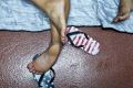 Sandals decorated with a US flag motif lay next to its owner, a Cuban migrant sleeping inside of a public restroom ...