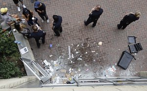 Police stand by a damaged storefront on Trade Street in uptown stemming from overnight protests following Tuesday's police shooting of Keith Lamont Scott in Charlotte, N.C., Thursday, Sept. 22, 2016.