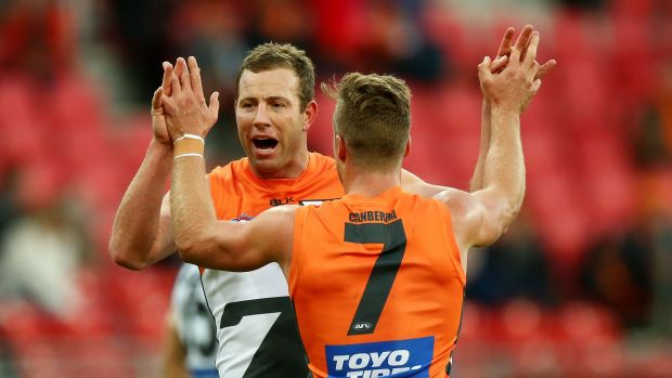 Celebration: Steve Johnson gets high fives from Rhys Palmer after kicking one of his four goals.