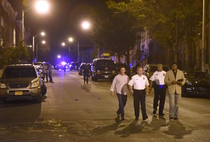 Baltimore police, from left, Deputy Commissioner Dean Palmere, Commissioner Kevin Davis, Stanley Brandord, chief of detectives, and T.J. Smith, police spokesman, walk at a scene where eight people were shot in Baltimore, Saturday, Sept. 24, 2016