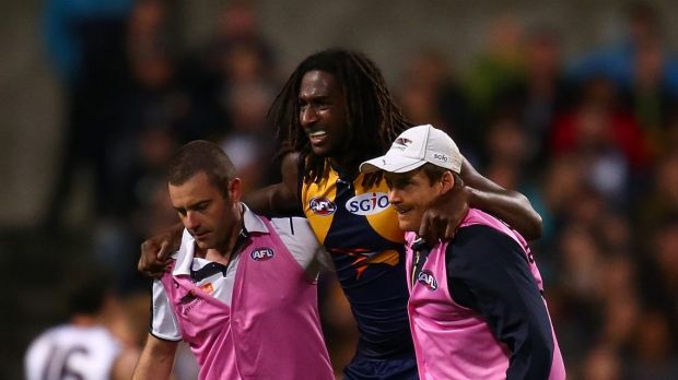 Nic Naitanui is helped from the ground after injuring his knee.