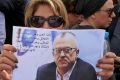 Relatives and friends of prominent Jordanian writer Nahed Hattar hold pictures of him and chant slogans against the ...