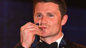 Patrick Dangerfield gives his Brownlow Medal a kiss.