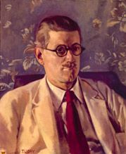 Half-length portrait of a fortyish man wearing distinctive Windsor (circular-lens) glasses with black Zylo-covered frames, short and slicked-down brown hair, a small mustache, light tan jacket and brown tie. His mouth is turned down in a slightly truculent expression