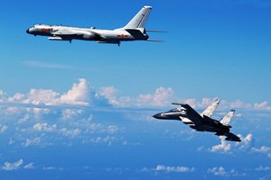 In this Sunday, Sept. 25, 2016 photo released by Xinhua News Agency, Chinese People's Liberation Army Air Force Su-30 fighter flies along with a H-6K bomber as they take part in a drill near the East China Sea.