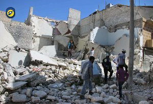 In this photo provided by the Syrian Civil Defense group known as the White Helmets,  shows members of Civil Defense and residents inspecting damaged buildings after airstrikes hit the Bustan al-Qasr neighborhood in Aleppo, Syria, Sunday, Sept. 25, 2016.