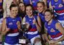 Meg Hutchins of the Bulldogs and teammates pose with the cup after the win. 