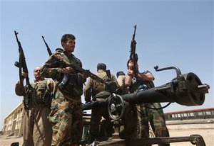 Kurdish peshmerga fighters take positions on the front line with militants from the al-Qaida-inspired Islamic State in Iraq and the Levant (ISIL), in Tuz Khormato