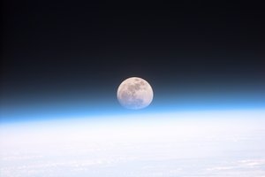 File - This view from orbit shows the full Moon partially obscured by the Earth's atmosphere.