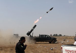 In this Monday, March 30, 2015 file photo Iraqi security forces launch a rocket against Islamic State extremist positions during clashes in Tikrit, 130 kilometers (80 miles) north of Baghdad, Iraq.