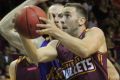 Brisbane guard Adam Gibson glides to the basket past Sydney Kings centre Aleks Maric on Saturday night.