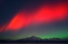 Vivid red Northern Lights shine above Pioneer Peak in Palmer, Alaska.