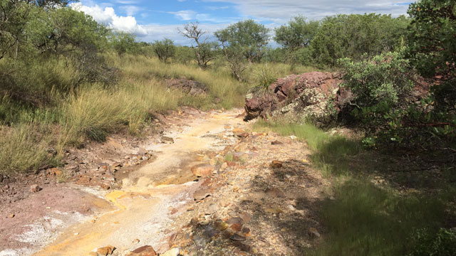 The wash beneath the Lead Queen Mine in southern Arizona remains stained from acid mine drainage. This wash leads to the watershed for the town of Patagonia. (Source: CBS 5 Investigates)