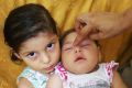 Seven-month-old Luhandra Vitoria, who was born with microcephaly, sits with her sister Jasminy in Recife, Brazil, where ...