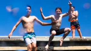 Children jumping off the wharf at Chowder Bay on Sunday.