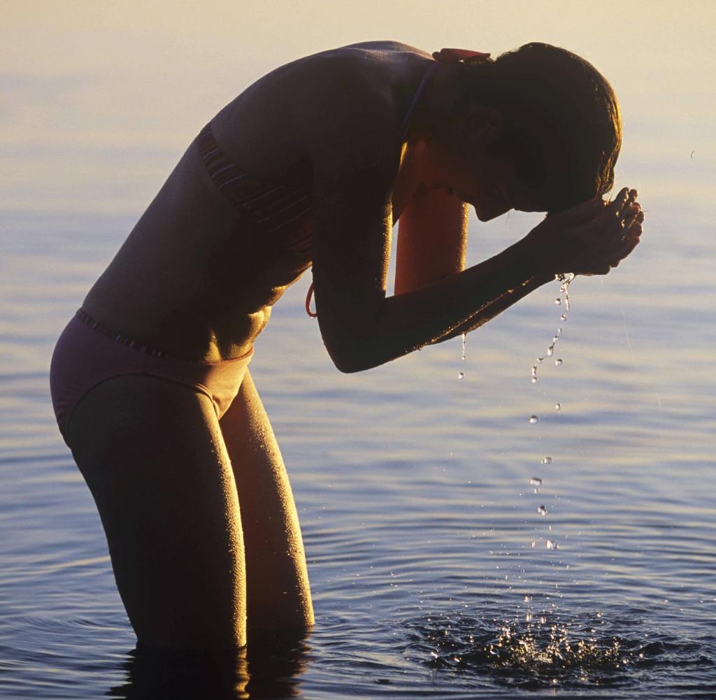 Frau steht im Wasser in der Abendsonne