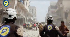 FILE - In this Sunday, April 24, 2016, file photo made from video posted online by the Syrian Civil Defense White Helmets, Civil Defense workers run after airstrikes and shelling hit Aleppo, Syria.