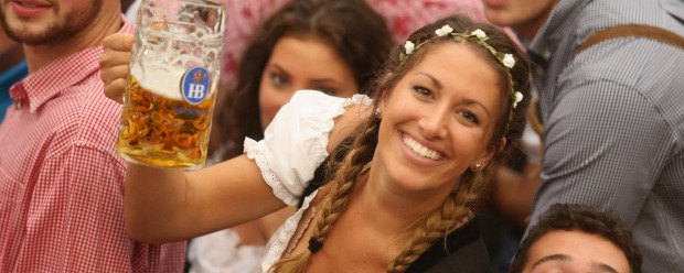 MUNICH, GERMANY - SEPTEMBER 17: Visitors hold up one-litre glasses of beer to kick off the 2016 Oktoberfest beer ...