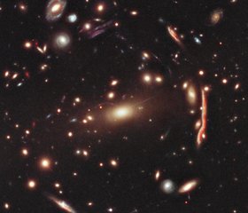 File - This image of galaxy cluster MACS J1206.2-0847 (or MACS 1206 for short) is part of a broad survey with NASA's Hubble Space Telescope.  The distorted shapes in the cluster are distant galaxies from which the light is bent by the gravitational pull of an invisible material called dark matter within the cluster of galaxies.