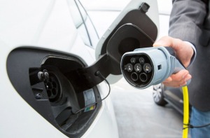 A driver charges a Volkswagen e-Golf electric automobile at a charging station outside the Volkswagen factory in ...