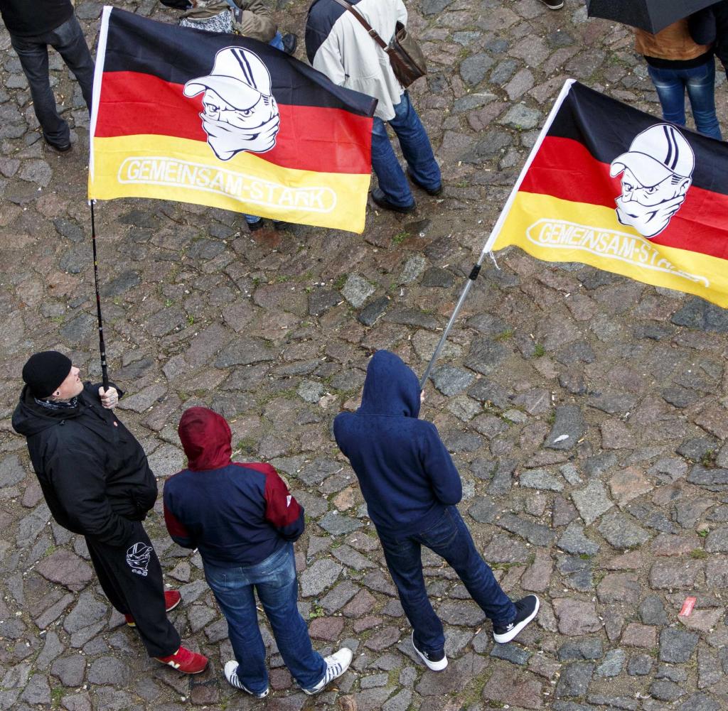 Demonstranten stehen in Dresden zum Tag der Deutschen Einheit