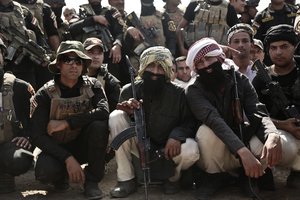 In this Saturday, Aug. 13, 2016 file photo, soldiers from the 1st Battalion of the Iraqi Special Operations Forces wear fake beards after playing the part of Islamic State militants during a training exercise to prepare for the operation to re-take Mosul from IS, in Baghdad, Iraq.