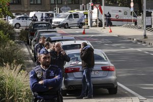 Police officers investigate the scene where a man stabbed two police officers, in the Schaerbeek neighborhood in Brussels, Wednesday, Oct. 5, 2016.