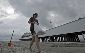 Miroslava Roznovjakova, formerly of the Czech Republic, fills sandbags on the beach for use in front of her store Thursday, Oct. 6, 2016, in Daytona Beach, Fla.