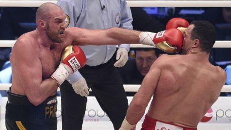 Troubled: World heavyweight champ Tyson Fury (left) fights Wladimir Klitschko last year. The rematch has been postponed ...