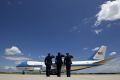 Military personnel salute as Air Force One, with President Barack Obama and Democratic presidential candidate Hillary ...