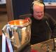 United: Bulldogs' chairman Peter Gordon on radio with the premiership cup.