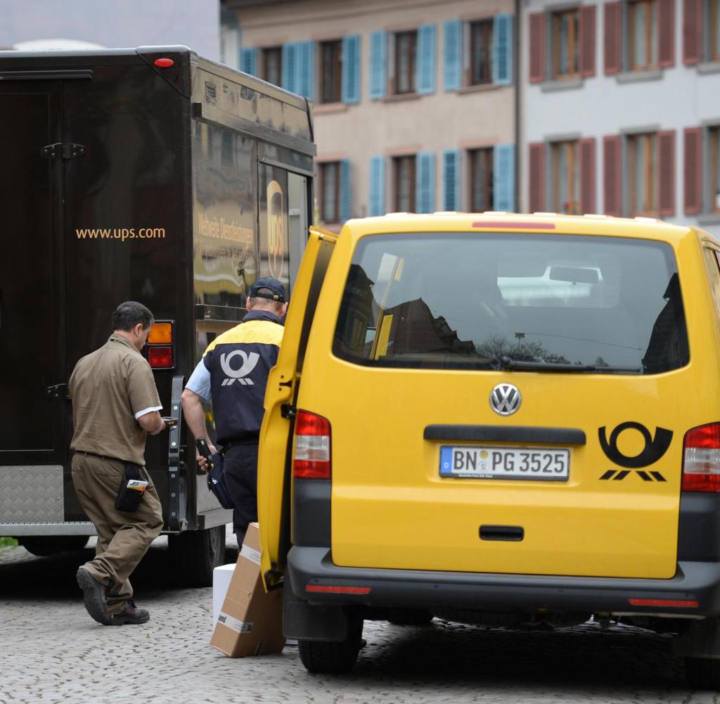 Fahrzeuge der Logistikunternehmen Deutsche Post und UPS versperren die Straße