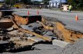 Workers block a road damaged by floodwaters caused by rain from Hurricane Matthew in North Carolina.