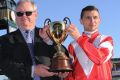 Opie Bosson poses with trophy and trainer Murray Baker after Mongolian Khan won Race 9.