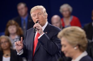 Republican presidential nominee Donald Trump speaks as Democratic presidential nominee Hillary Clinton listen during the second presidential debate at Washington University in St. Louis, Sunday, Oct. 9, 2016.