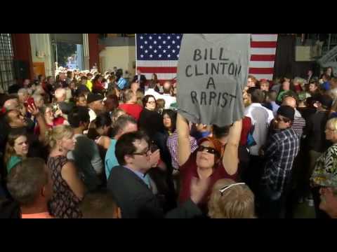 Protester Intertupts Bill Clinton With A  'Bill Is A Rapist' Sign