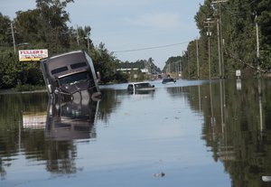 A tractor trailer truck is submerged in floodwaters caused by rain from Hurricane Matthew on Highway NC 211 near the Mayfair neighborhood in Lumberton, N.C., Tuesday, Oct. 11, 2016.