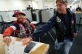 John Olsen and Mark Cooper race to be the first to get their ballot in the box on the first day of early voting.