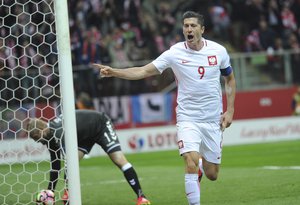 Poland's Robert Lewandowski celebrates after scoring a goal as Denmark's goalkeeper Kasper Schmeichel, left, picks the ball during their World Cup Group E qualifying soccer match at the National Stadium in Warsaw, Poland