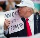 Republican presidential candidate Donald Trump kisses a 'Women for Trump' sign at a campaign rally in Florida. 